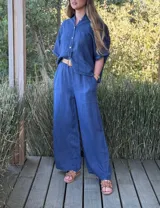 Pantalón blanco de lino, de corte ancho, con cintura elástica y cinturón de rafia extraíble.