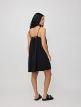 Vestido corto fucsia de algodón y lino, con breteles finos y escote recto con lazo ajustable.