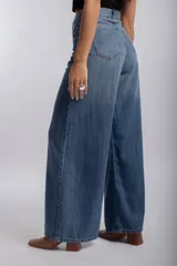 Pantalón jean wide leg de tiro alto, color azul claro, con diseño amplio y fluido en las piernas, bolsillos delanteros y traseros.