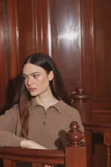 Sweater de punto color taupe, con cuello polo y cierre frontal parcial de botones, de manga larga y calce holgado.