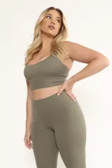 Top deportivo color verde oliva con tirantes cruzados en la espalda y almohadillas removibles.