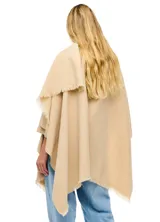 Ruana de tejido soft color negro, con cuello en V y un nudo o pasador frontal que ajusta la prenda. Los bordes tienen terminación desflecada.