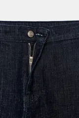 Pantalón de tiro alto confeccionado en mezcla de algodón, con diseño de pierna ancha y corte evasé. Presenta cierre frontal con cremallera y botón, y falsos bolsillos de vivo en la parte trasera.