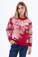 Buzo tejido de punto con diseño floral estampado en contraste, cuello redondo y terminaciones en rib. Presenta un calce holgado y mangas largas.