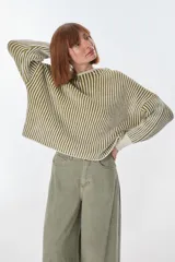 Sweater de punto a rayas verticales blancas y negras, con cuello redondo y mangas largas.