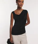 Blusa sin mangas color gris con escote asimétrico y detalles drapeados.