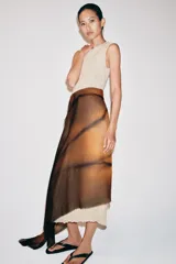 Pañuelo rectangular estampado con diseño degradado en tonos tostado y marrón oscuro, confeccionado en mezcla de modal y seda, con bordes deshilachados.