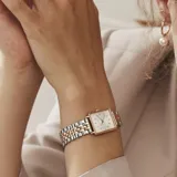 Reloj Rosefield modelo The Boxy XS con caja cuadrada de acero dorado y esfera blanca con función de fecha. Malla bicolor en tonos plata y oro.