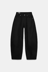Jeans de tiro medio estilo balloon en color negro, con diseño de cinco bolsillos, trabillas para cinturón y cierre frontal con cremallera y botón metálico.