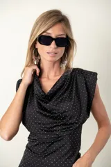 Blusa negra con lunares blancos, cuello drapeado y corte ajustado.