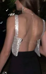 Top corto plateado con strass, breteles anchos y espalda regulable.