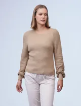 Buzo color beige de tejido combinado con mangas largas caladas y cuello redondo.