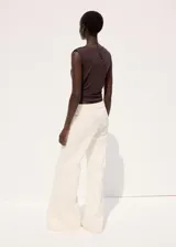 Jeans de algodón tiro medio, diseño acampanado estilo flare de corte largo, con trabillas, cinco bolsillos y cierre frontal de botón y cremallera.
