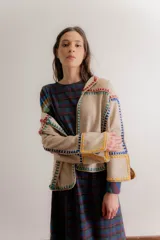 Chaqueta gris de paño de lana con detalles de crochet rojo, corte cuadrado y cuello camisero.