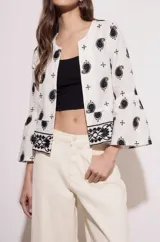 Blusa blanca con bordado de cachemir en negro, corte oversize y mangas acampanadas.