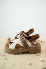 Sandalias de cuero color tostado y blanco, con plataforma track y hebilla metálica.