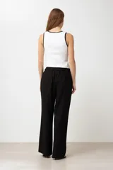Pantalón negro de lino, corte palazzo, con cintura elástica y cordón ajustable.