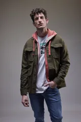 Camisa gruesa de gabardina color azul marino, con cuello clásico, cierre frontal con botones a presión, cuatro bolsillos frontales con solapa y puños abotonados.