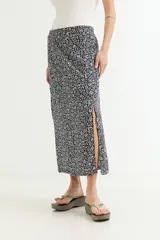 Falda midi cruzada (wrap) de viscosa, color azul marino con estampado floral pequeño en blanco. Presenta un tajo lateral pronunciado.