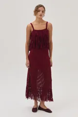 Falda midi tejida color bordó, con flecos y calados en el bajo.