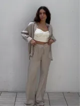 Camisa de satén color beige con estampado abstracto, corte holgado y mangas largas.