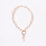 Collar tipo gargantilla de eslabones gruesos dorados, con un anillo central del que cuelgan tres eslabones más pequeños. Posee cadena de ajuste en el cierre.