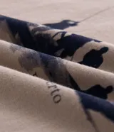 Remera de algodón color beige con cuello redondo y manga corta. Presenta una estampa frontal en azul oscuro que representa a un grupo de personas en un bote pescando.