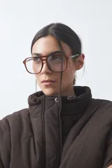 Campera acolchada de nylon color negro, con cuello alto, cierre frontal y botones a presión. Presenta un diseño de rombos y forro interior suave.