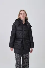 Campera puffer negra de corte largo y holgado, con capucha, cierre frontal y bolsillos delanteros con solapa.