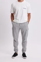 Pantalón deportivo tipo jogger en color gris claro, con diseño cargo que incluye bolsillos laterales. Presenta cintura elástica con cordón ajustable y puños elásticos en los tobillos.