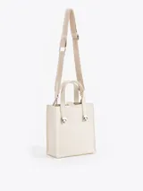 Cartera tipo tote pequeña de cuero color tostado, con doble asa superior y herrajes metálicos plateados en forma de llama en la base de las manijas. Presenta el logo de la marca estampado en la parte inferior frontal.