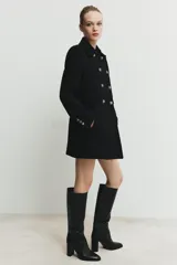 Abrigo corto de paño con mezcla de lana, cuello solapa y manga larga con hombreras. Presenta un diseño de doble botonadura con cierre frontal cruzado y falsos bolsillos de solapa en el delantero.