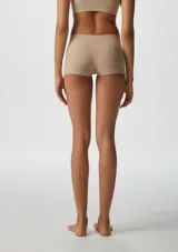 Bombacha tipo boxer de tiro medio, confeccionada en tejido sin costuras de color beige, diseñada para un ajuste cómodo y discreto.