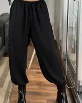 Pantalón estilo balloon de tela cey, color negro, con corte holgado y ajuste en los tobillos.