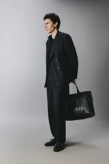Pantalón de traje negro de corte regular fit, con pinzas delanteras, bolsillos laterales y cierre frontal con cremallera y botón.