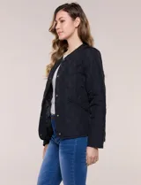 Campera matelaseada color verde militar con diseño capitoneado de rombos, escote redondo sin cuello y cierre frontal con broches a presión. Cuenta con bolsillos frontales oblicuos y ruedo curvo con aberturas laterales.