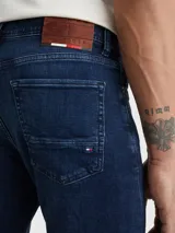 Pantalón de jean Tommy Hilfiger modelo Bleecker, corte slim, color azul oscuro. Confeccionado en tejido denim Power Stretch de mezcla de algodón, con efecto desteñido en las rodillas, estilo de cinco bolsillos y logo bordado en el bolsillo trasero.