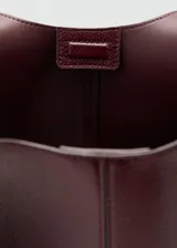 Bolso tipo tote color bordó, de diseño estructurado, con correa para el hombro y solapa frontal.