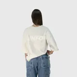 Remera de corte oversize color beige, con diseño estampado en la espalda que incluye el texto VNFO y leyendas adicionales.