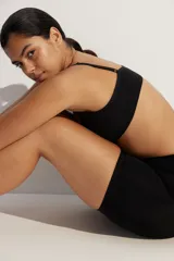 Sujetador suave de punto color negro, con tirantes ajustables y copas forradas con relleno extraíble. Presenta un ribete de canalé en el bajo y no tiene cierre.