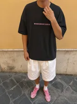 Remera oversize gris con efecto acid wash y estampa frontal con la leyenda "WORLDWIDE TOUR" en tipografía gótica.