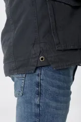 Campera de algodón color azul marino con cuello alto, cierre frontal con cremallera y botones a presión, cuatro bolsillos frontales con solapa y puños con botón.