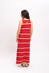 Vestido largo de tejido de punto con diseño de rayas en zigzag de colores rojo, fucsia y amarillo. Presenta cuello redondo y diseño sin mangas.