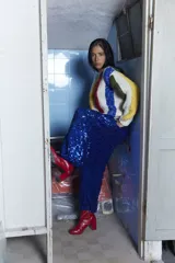 Sweater tejido a mano en lana merino con diseño a rayas verticales de colores sobre fondo crudo, cuello redondo y calce holgado.