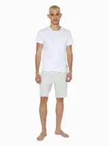 Short de dormir blanco de corte holgado, con cintura elástica negra que lleva el logo de Calvin Klein en verde neón.