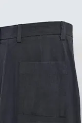 Pantalón de vestir negro, corte recto y relajado, con cintura elástica, cierre frontal con cremallera y botón, bolsillos delanteros y bolsillos traseros de plastrón.