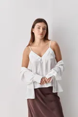 Top negro de breteles finos con escote en V y diseño minimalista, confeccionado en tela fluida y suave.