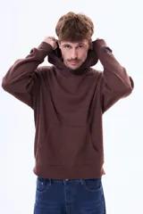 Buzo tipo canguro de felpa color gris, con capucha amplia, bolsillo frontal tipo canguro y puños acanalados.