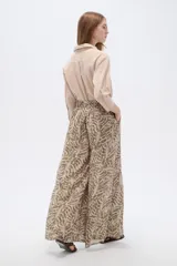 Pantalón de poliéster ancho con estampado botánico en tonos verde militar y beige, de tiro alto.
