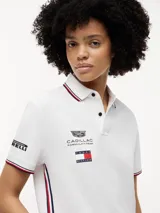 Chomba de corte regular confeccionada en algodón elástico, con cuello polo y cartera de dos botones. Presenta ribetes distintivos en cuello y puños, cinta lateral y múltiples logos bordados que incluyen Tommy Hilfiger, Cadillac Formula 1 Team y Pirelli.